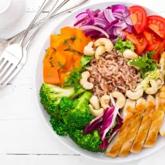 Un plat coloré avec poulet, riz brun, brocolis, carottes, tomates, oignons rouges et pois chiches. Une belle façon de manger sain et pas cher.