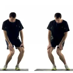 Homme effectuant un exercice de renforcement du genou, en position accroupie avec les mains sur les genoux.