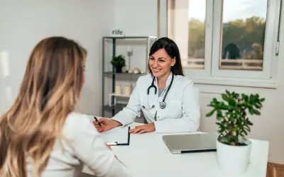 Sage-femme souriante discutant avec une patiente, évoquant une possible rééducation périnée.