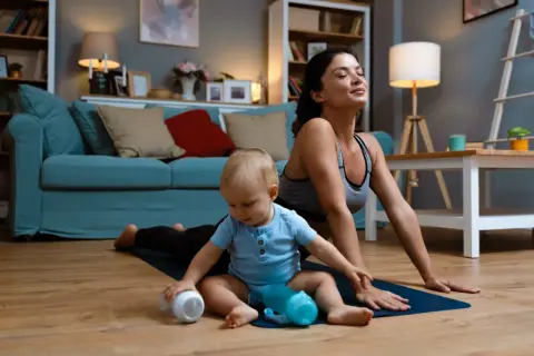 Une mère fait du yoga avec son bébé. Elle pense à sa rééducation périnée quand.