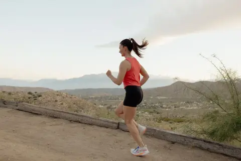 Femme courant dans un paysage désertique. Apprenez comment protéger son périnée en courant pour une meilleure expérience sportive.