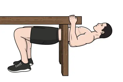 Homme faisant un exercice de traction biceps sous une table en bois, jambes pliées, pieds au sol.