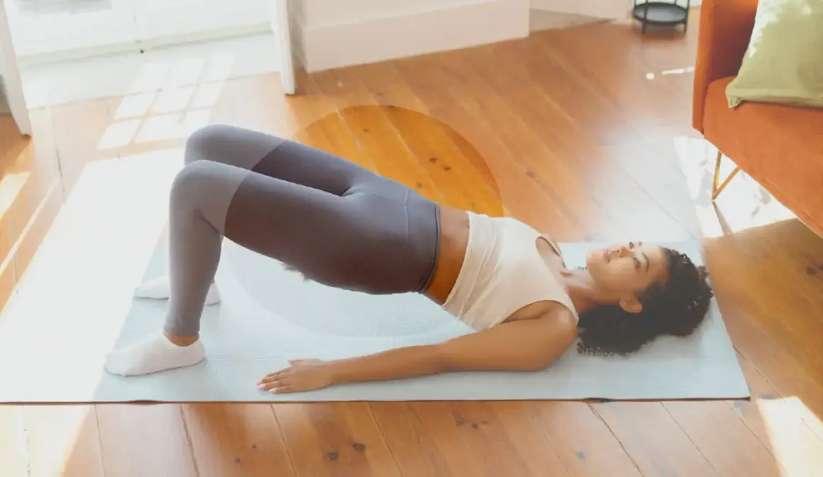 Femme en tenue de sport effectuant un pont sur un tapis, une posture idéale pour muscler son périnée et renforcer son corps.