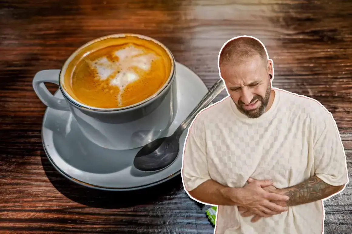 Un homme se tient le ventre, visiblement souffrant, à côté d'une tasse de café. Il semble que boire beaucoup de café lui ait causé des maux d'estomac.
