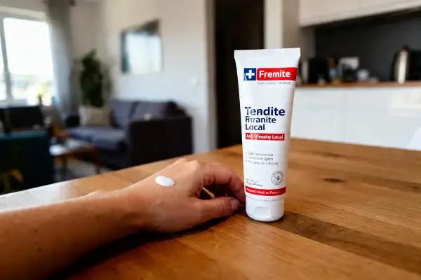 Crème anti-inflammatoire pour tendinite locale appliquée sur une main.