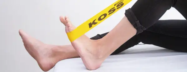 Exercice avec élastique jaune pour soulager la périostite tibiale.